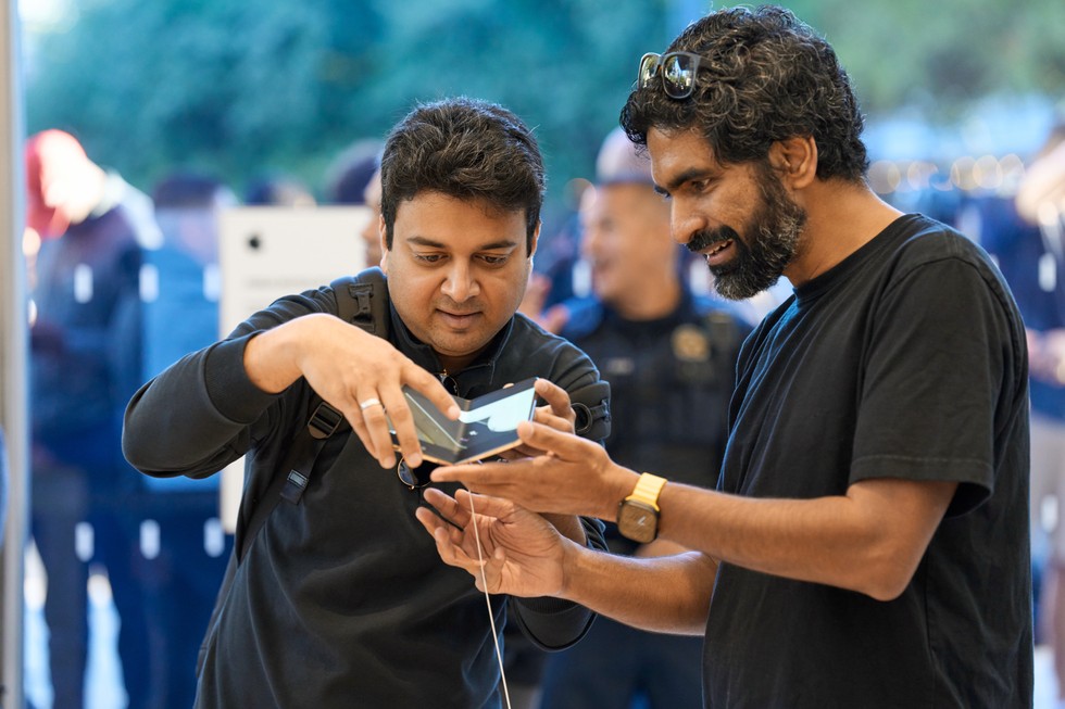 Dos Clientes Prueban La Bisagra Del Iphone Duo En Una Mesa De Exhibición De La Apple Store De Austin