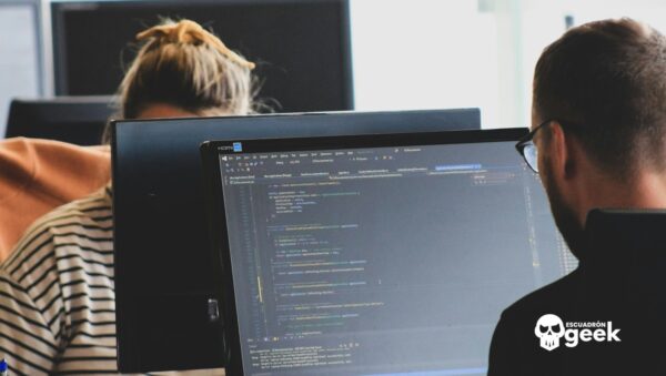 Programadores Trabajan Frente A Monitores Con Código, En Referencia A La Contratación De Juniors En Anthropic